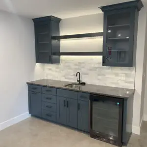 basement wet bark with dark grey cabinets and a black sink - Halloran Brothers