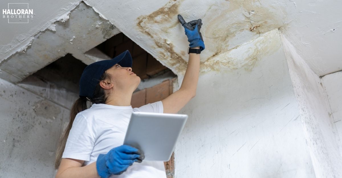 woman uncovering water issue in the ceiling - Halloran Brothers water damage