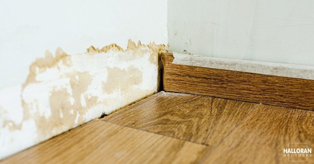 close up of a wall and floor with water damage stains - Halloran Brothers water damage insurance claim